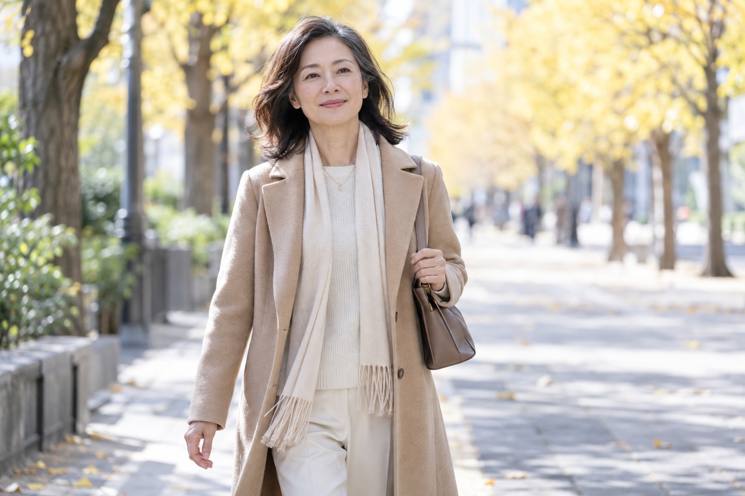 明るい並木道を、前を向いて歩く女性