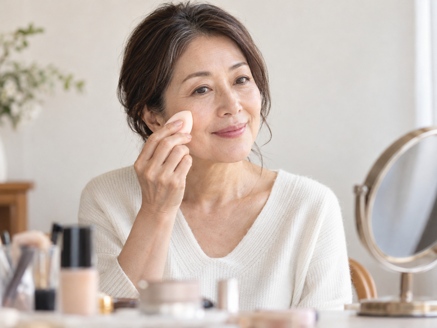 スポンジでファンデーションを塗る50代女性のイメージ